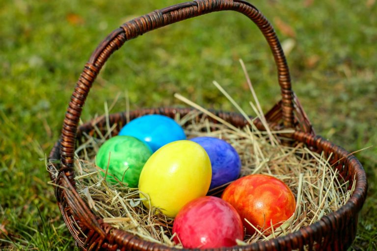 wicker basket with easter eggs on hay